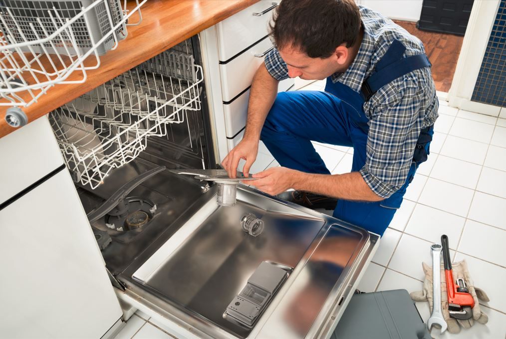 Appliance repair technician fixing a fridge in Centurion